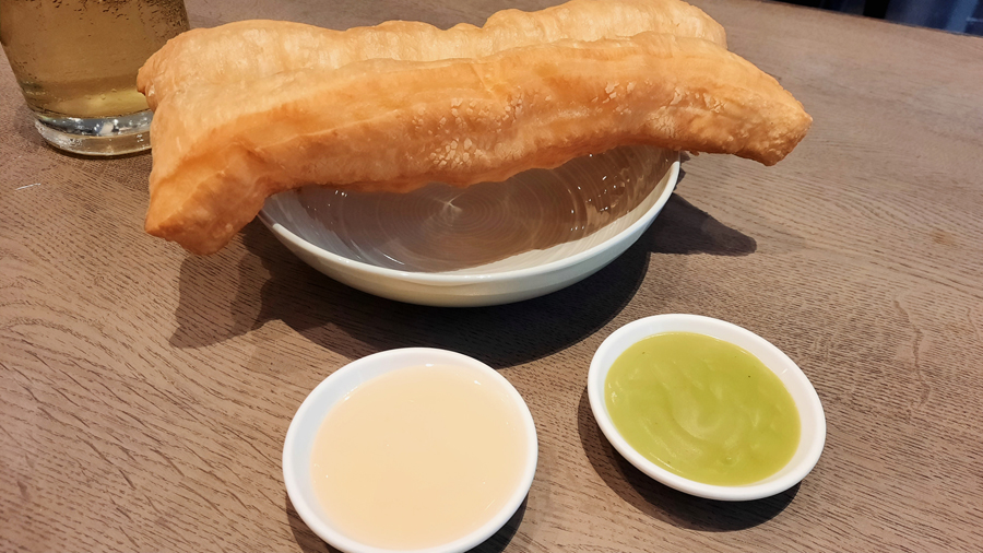 Signature patongo deep-fried dough dessert with condensed milk and pandan custard at Coca Chinese hotpot restaurant on Sukhumvit Soi 39, Bangkok